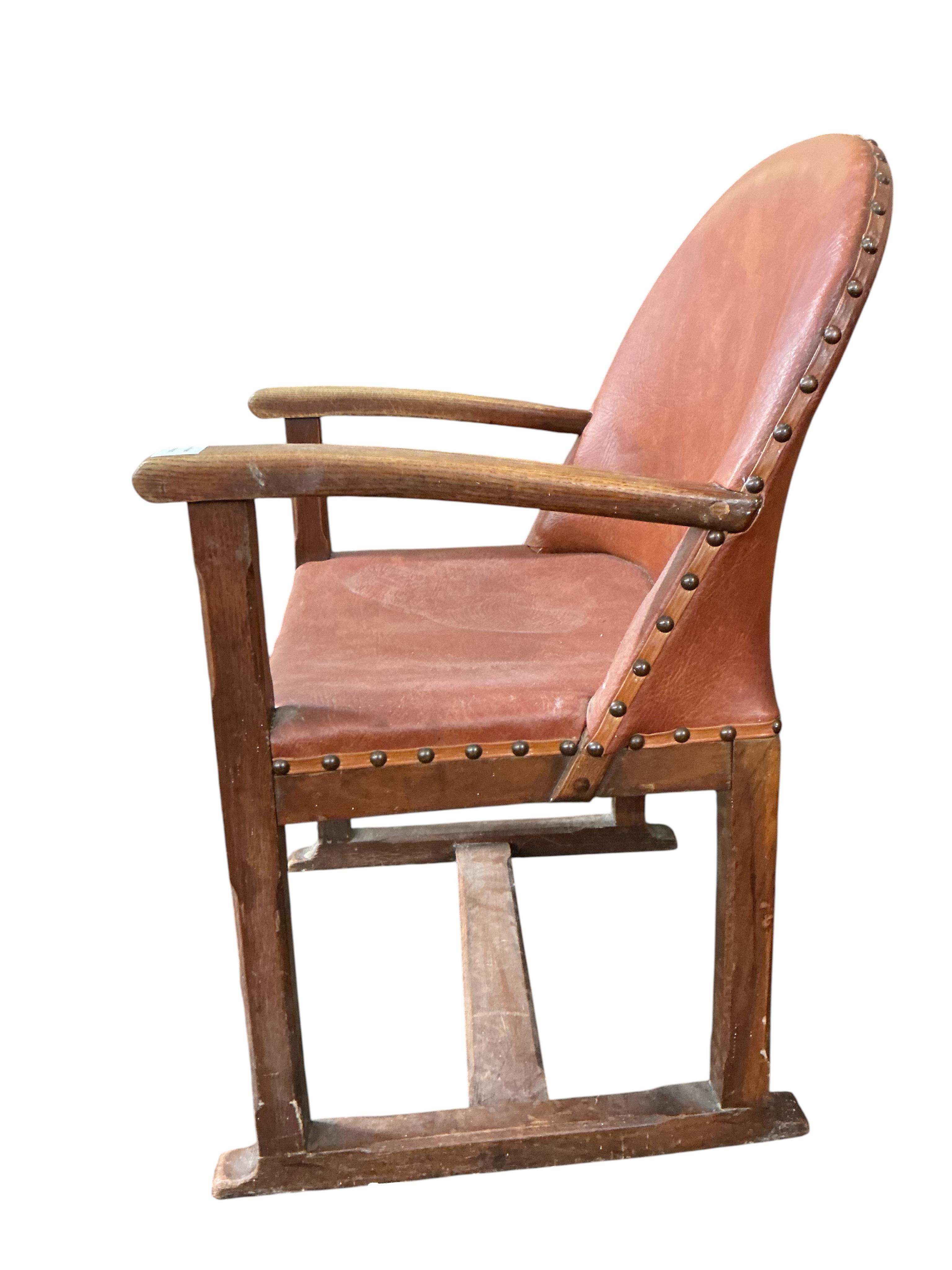 A 1920's oak Arts and Crafts leather upholstered desk chair, width 57cm, depth 42cm, height 82cm